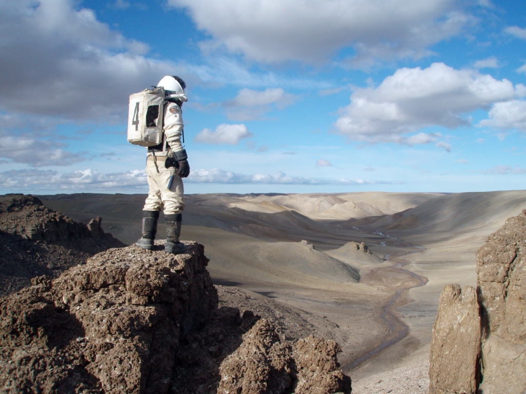 Crewmember of the Flashline Mars Arctic Research Station (FMARS) climbs Castle Mercury for a final view of Devon Island on the last EVA of a four-month Mars simulation.
